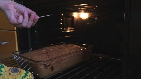 Sponge cake is baked in the oven, it is checked for readiness with a toothpick Stock Footage 235422988