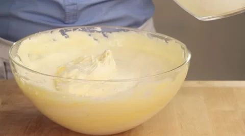 Sponge cake being made: flour being sieved into a beaten egg white and egg yolk Stock-Footage 24671030
