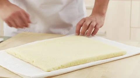 Sponge cake being rolled up with the aid of a cloth Stock Footage 24638983