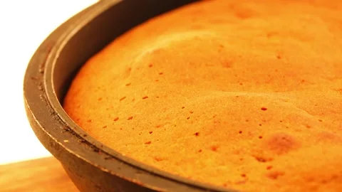 Sponge cake in a black frying pan is rotated in a circle on the table. Stock Footage 141799706