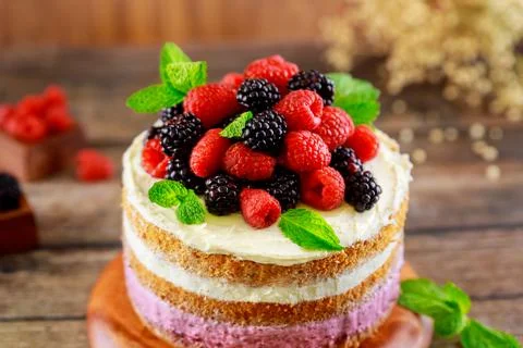 Sponge cake with fresh raspberry and blackberry. Stock Photos