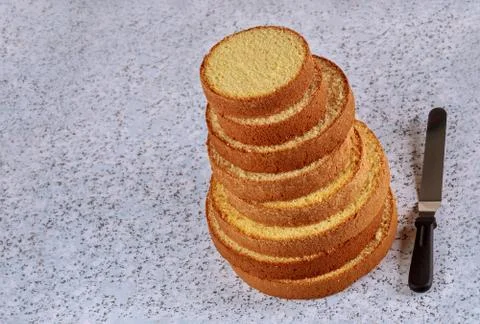 Sponge cake layers with spatula. Making wedding cake. Stock Photos