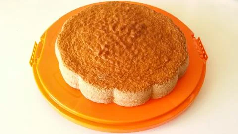 Sponge cake on orange tray Stock Photos