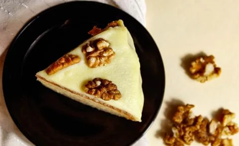 Sponge cake with walnuts and light cream on a black saucer. Foto stock