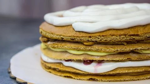 Sponge cake with white cream, the process of making the cake, side view Stock Photos