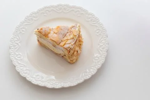 Sponge cake on a white plate on the table. Top view - flat lay Stock Photos