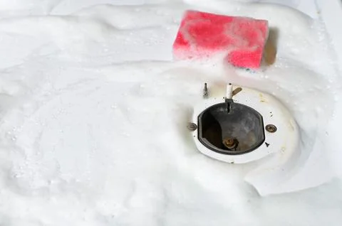 Sponge with foam lying on surface of gas stove, copy space. Hygienic cleaning Stock Photos