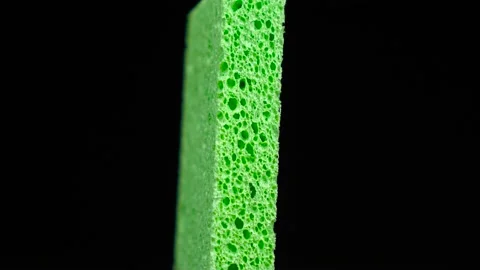 Sponge for housework rotates in front of black background Stock Footage 117446014