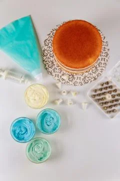 Sponge layered cake with tools for decoration. Stock Photos