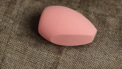 Sponge for makeup - rotates on a beautiful background. Cosmetics, makeup. Stock Footage 130346401