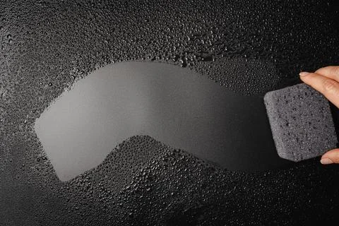 Sponge placed on wet black background Stock Photos