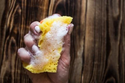 Sponge with soap bubbles in woman's hand Stock Photos