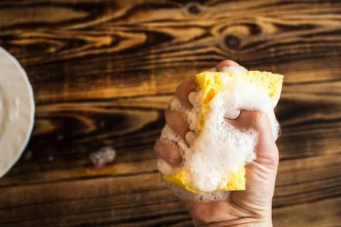 Sponge with soap bubbles in woman's hand Stock Photos