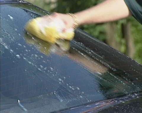 Sponging a car window by hand Stock Footage 125316979