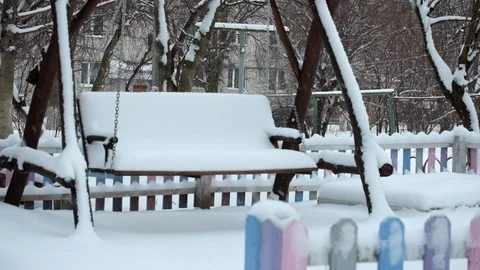 Spontaneous swinging of a swing during a snowfall. Phantom swing Stock Footage 101111656