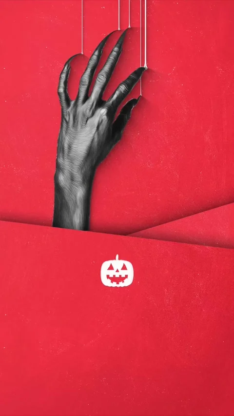 A spooky, clawed hand puppet emerges from a vibrant red background Stock Footage 317492884
