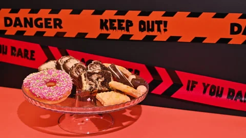 Spooky Delight: Skeleton Hand Grabs Donuts from Candy Basket Видео 251652475