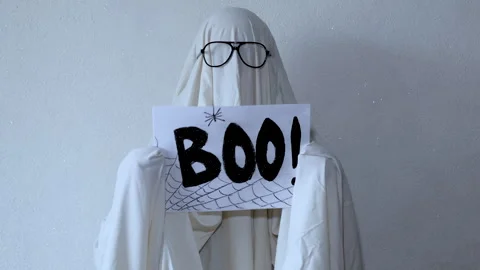 A spooky-funny Halloween concept featuring a person in a ghost costume and .. Stock Footage 314747619