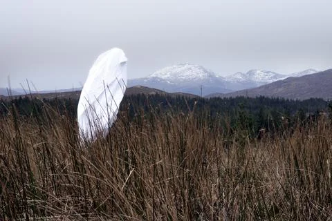 A spooky ghost in a sheet. Walking across a mountain on a winters day. Stock Photos