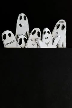 Spooky ghosts peeping out, playing at scaring. Black background.Paper art. Illustrazione stock