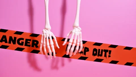 Spooky Halloween Decor: Hanging Skeleton Hands on Pastel Pink Stock Footage 251494579