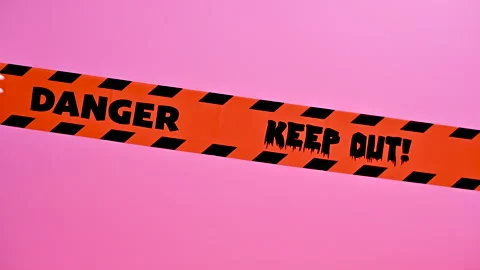 Spooky Halloween Decor: Skeleton Hands Interact with Warning Tape Stock Footage 251494393