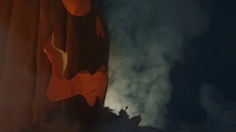 Spooky halloween pumpkin side profile billowing smoke Stock Footage 119339873