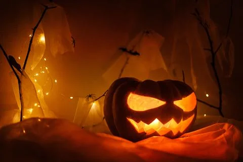 Spooky Jack o lantern carved pumpkin, spider web, ghost, bats and glowing l.. Stock Photos