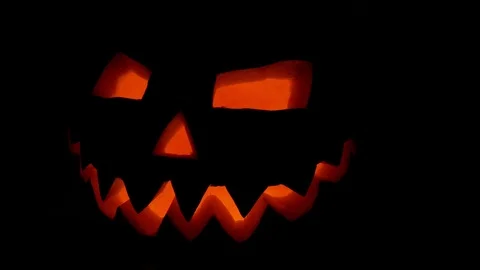 Spooky jack-o-lantern or carved pumpkin lantern burning in darkness. Stock Footage 116156381