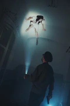 Spooky monster on the ceiling looking down at the security guard Foto stock