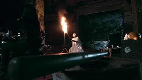 Spooky psycho in a mask fires a torch. Drummer plays drums Video stock 92178648