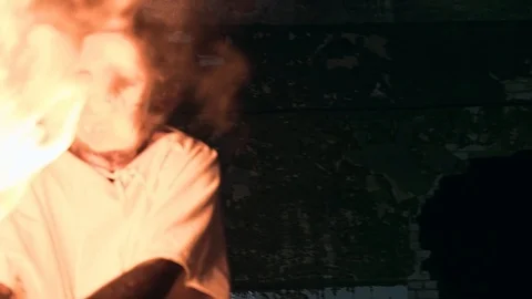 Spooky psycho in a mask waves a torch in an abandoned factory Stock Footage 92177314