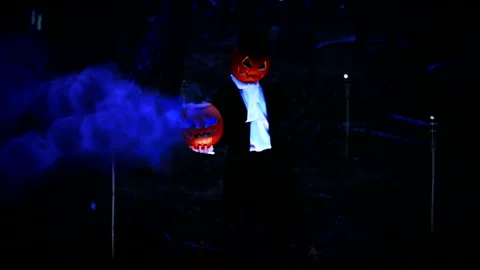 Spooky Pumpkin Headed Man Holding A Huge Pumpkin With Blue Smoke In The Forest Stock Footage 141257883