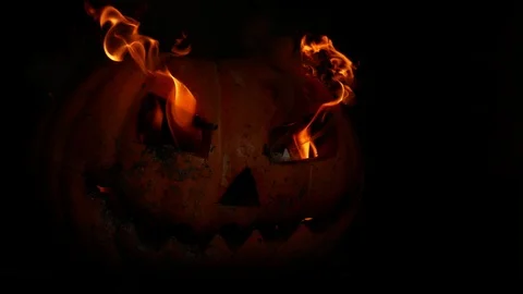 Spooky pumpkin jack-o-lantern face with fire in the eye of darkness.4k Stock Footage 116890609