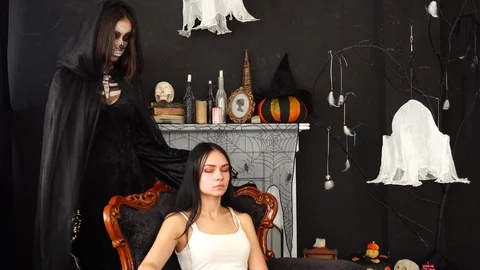 Spooky scary Skeleton make up Death Ripper costume woman gently stroking young Stock Footage 95881606