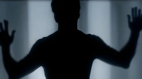 Spooky silhouette man standing in front of smoked glass Stock Footage 252631669