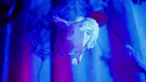 Spooky white paper ghost decoration spinning in neon blue light. Home Hallo.. Stock Footage 345087791