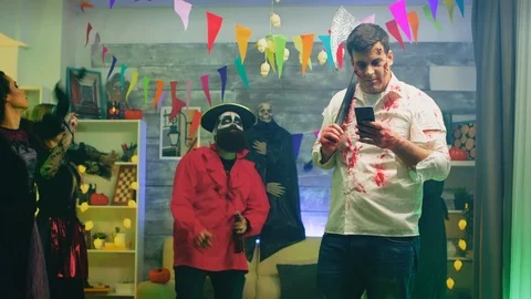 Spooky zombie with an axe using his phone Stock Footage 127020754