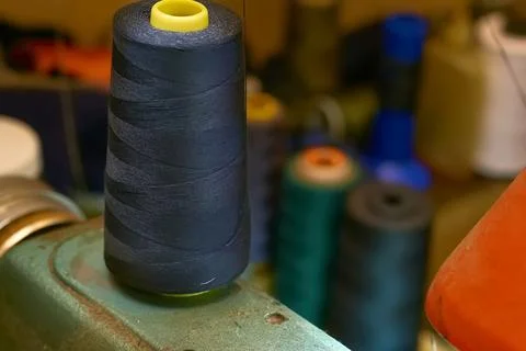 A spool of black thread on an old sewing machine in a tailor's workshop Stock Photos