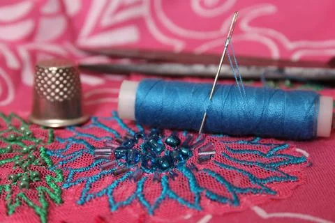 Spool of Blue Thread on Vintage Beaded Fabric Stock Photos