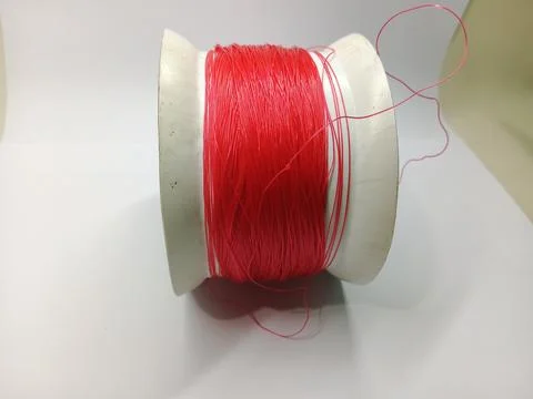 Spool of Bright Red Nylon Thread on White Background 库存照片