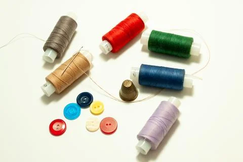 Spool of coarse thread and spool of colored thread, buttons and thimble on .. Stock Photos