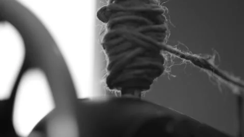 Spool of coarse thread spins as woman turns the handle of retro sewing machine Stock Footage 237724488