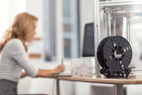 Spool with filament standing on the work desk Foto stock