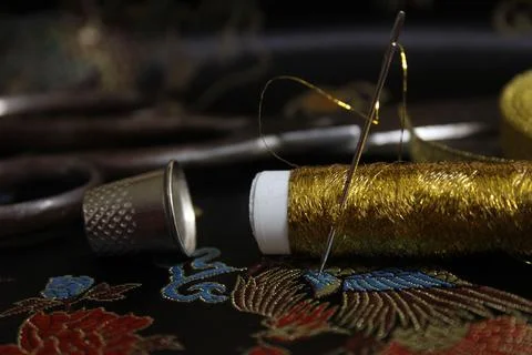 Spool of Gold Thread With Thimble on Vintage Black Silk Fabric Stock Photos