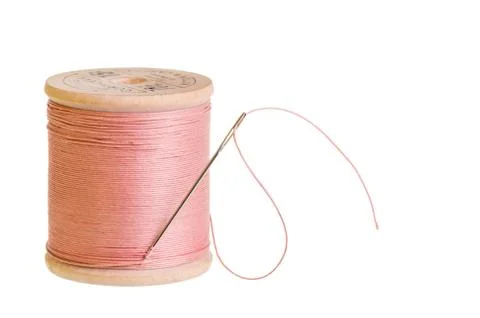 Spool of pink thread with needle 写真素材