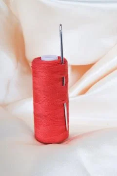 Spool of red thread with a needle Stockfoto's