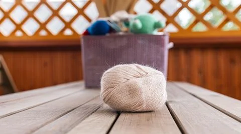 Spool of thread and a ball of yarn, both in a soft, neutral beige color. Stock Photos