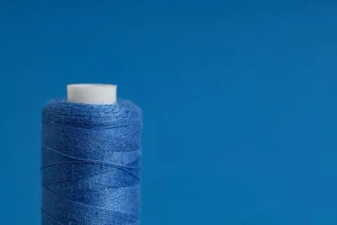 Spool of thread on blue background, closeup Stock Photos