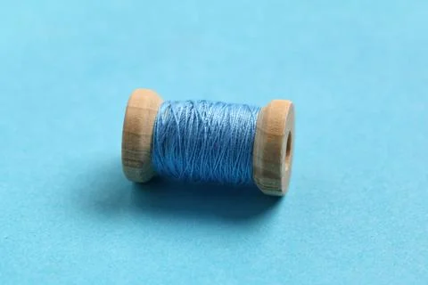 Spool of thread on blue background Stock Photos